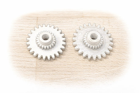 Replacement Porsche 944 odometer drive gears on a workbench, showing the fine teeth that drive the odometer.