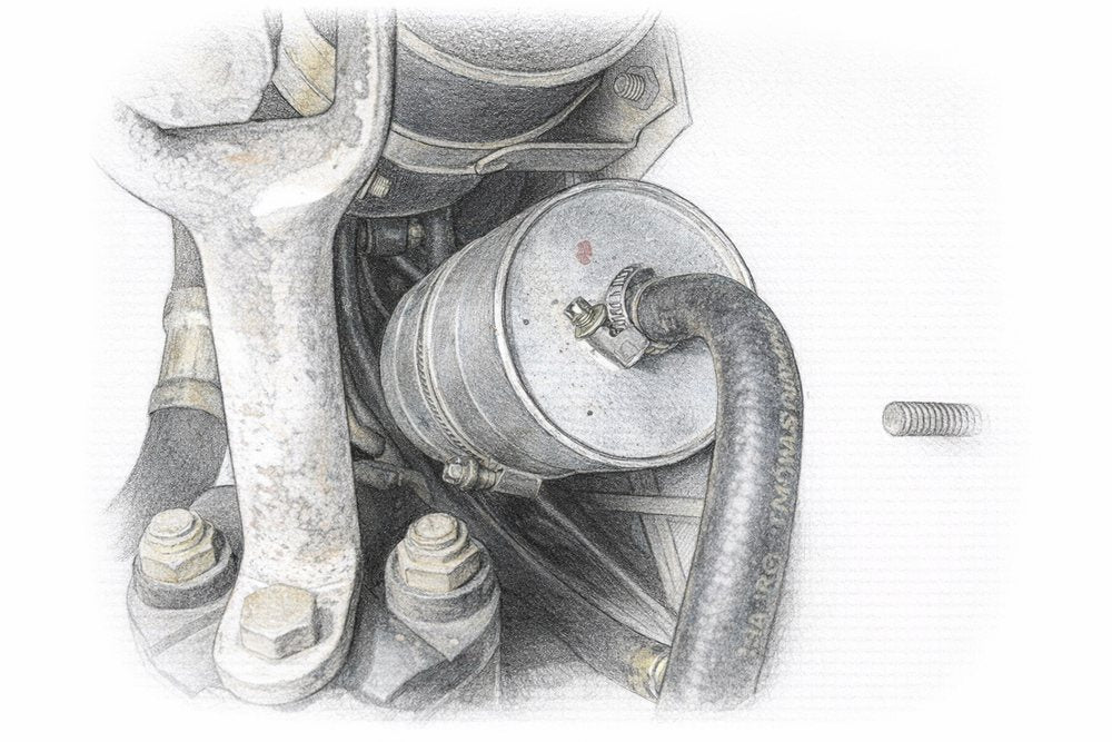BMW E36 fuel filter mounted under the car with its worm-gear hose clamp and fuel line attached.